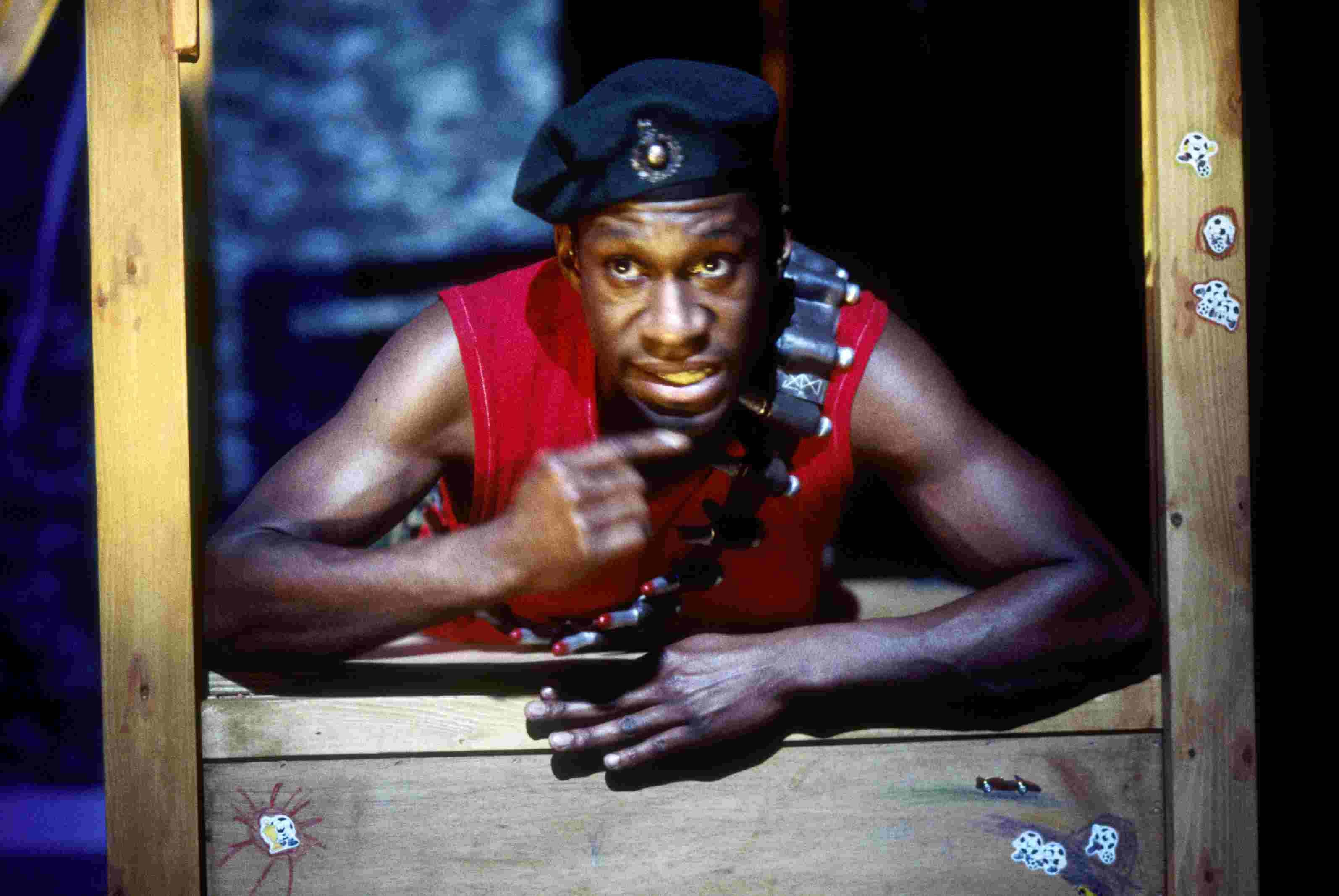 Thumbnail image for the 'Case study film: David Ellington' video. David is performing, wearing a soilder costume, and leaning through a window frame.