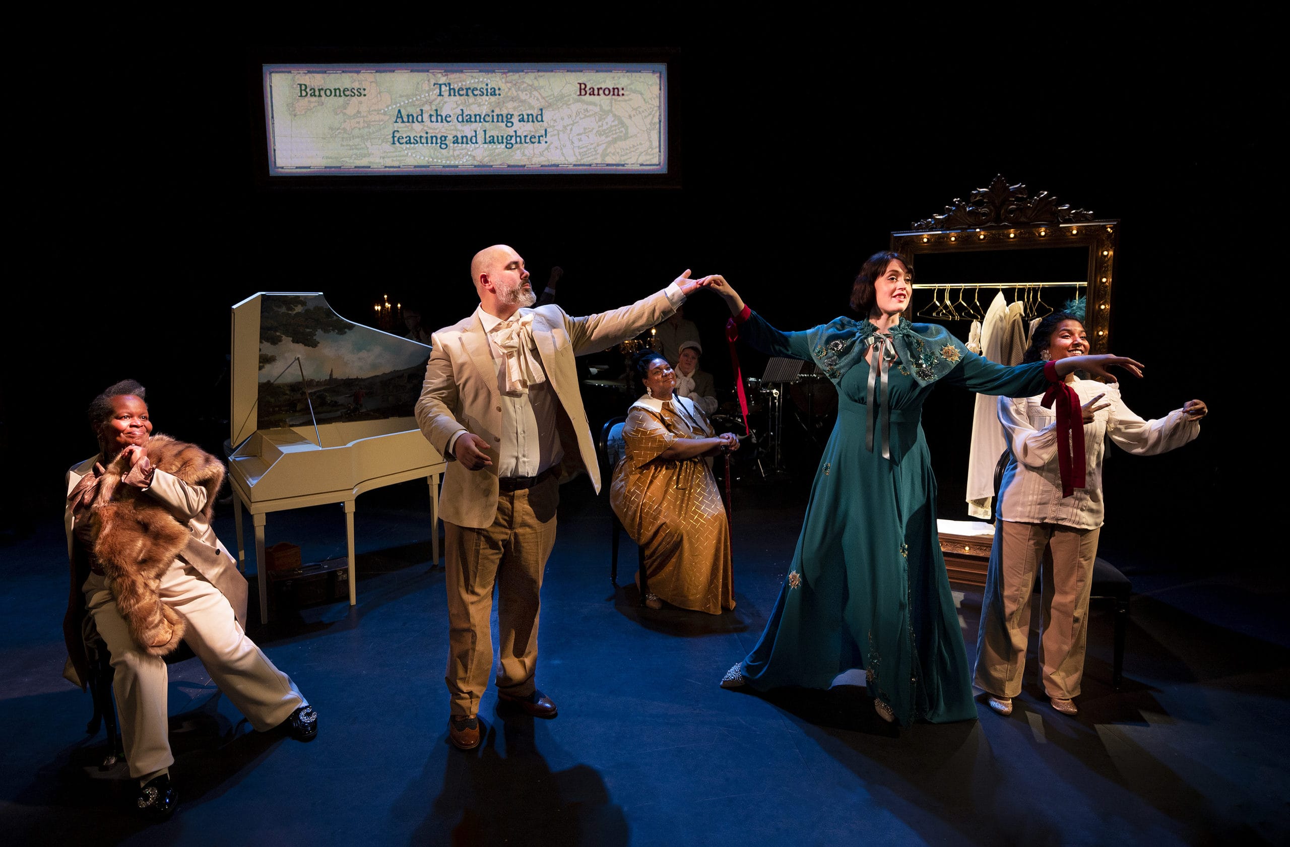 The cast of The Paradis Files are on stage, in costume. there is a grand paino on stage with them. They are dancing.