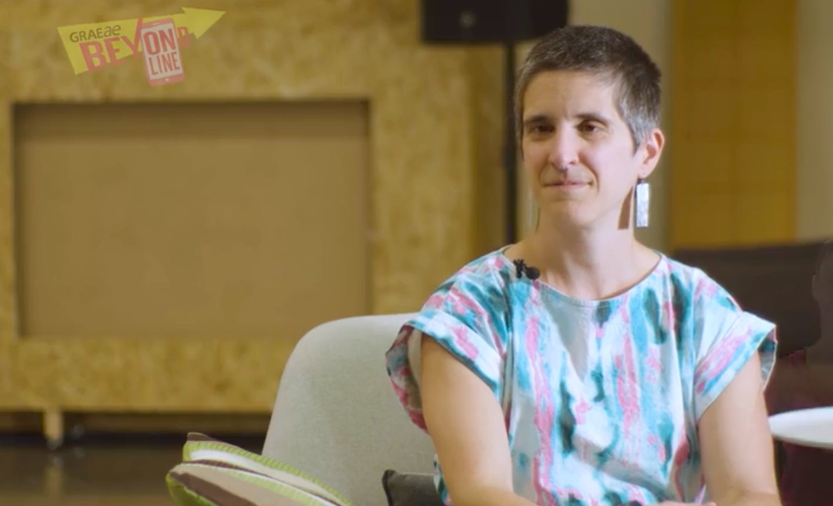 Thumbnail for the video 'Beyond Online: Amelia Cavallo case study' - a white person with short grey hair and a colourful blouse, sits looking at the camera.