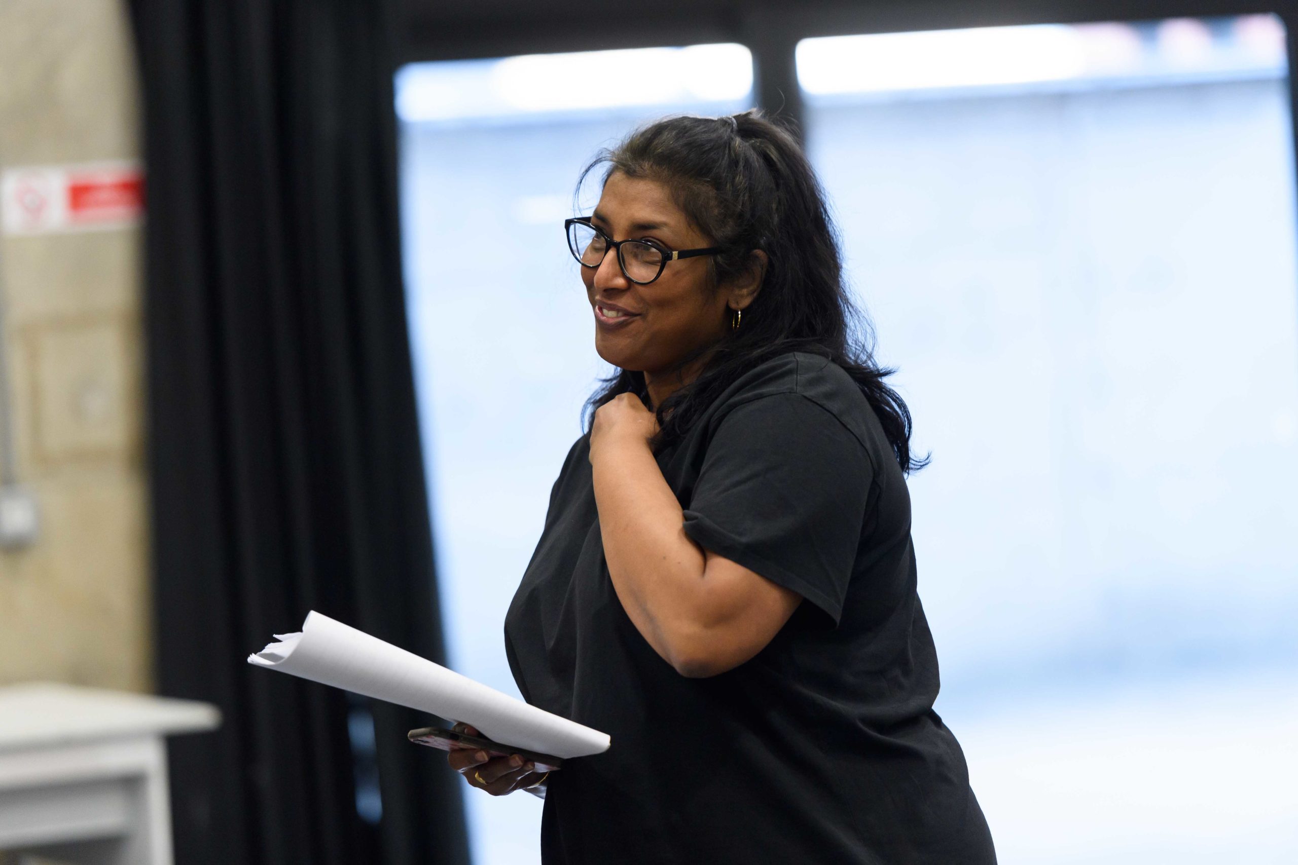 Rekha John-Cheriyan in rehearsal, she is holding a script in one hand.