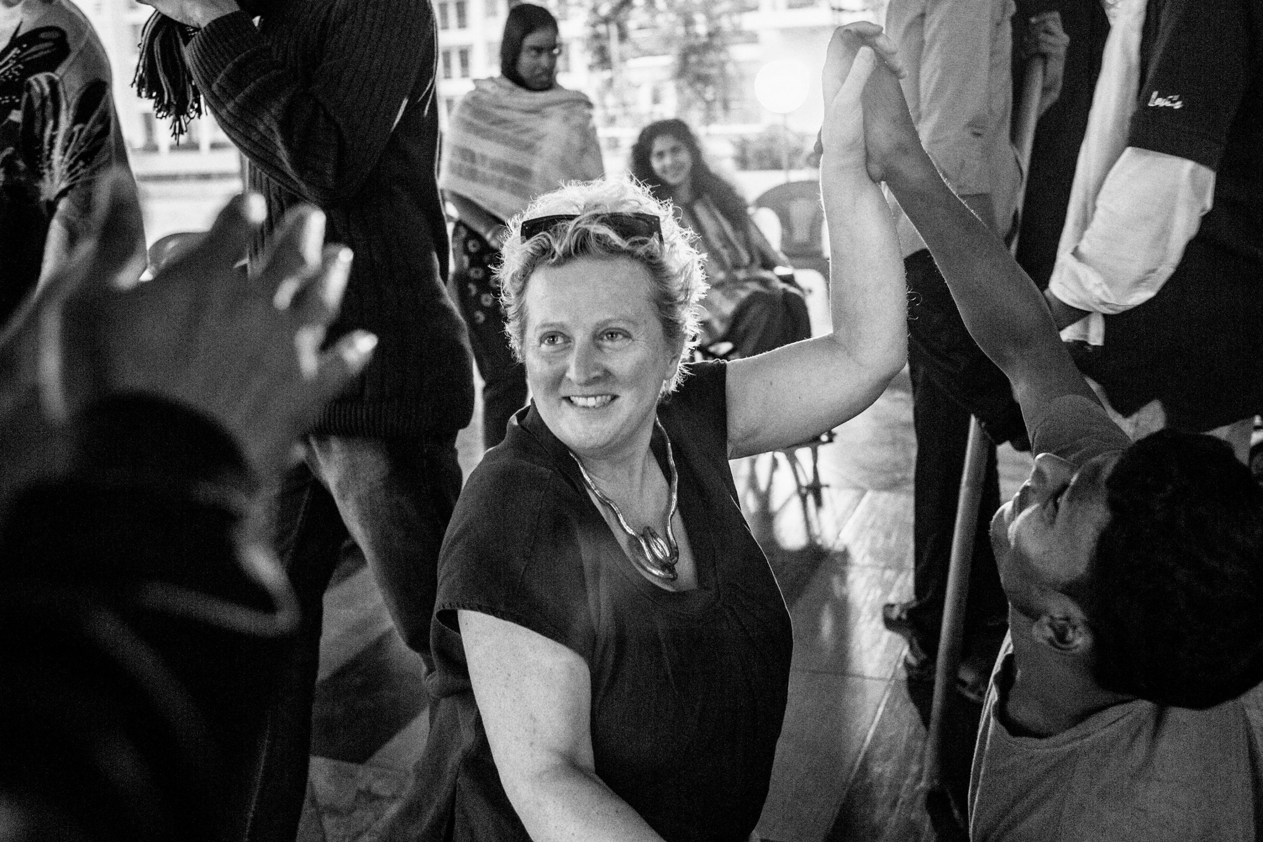 Jenny Sealy holds hands with a young performer and smiles at someone out of frame.