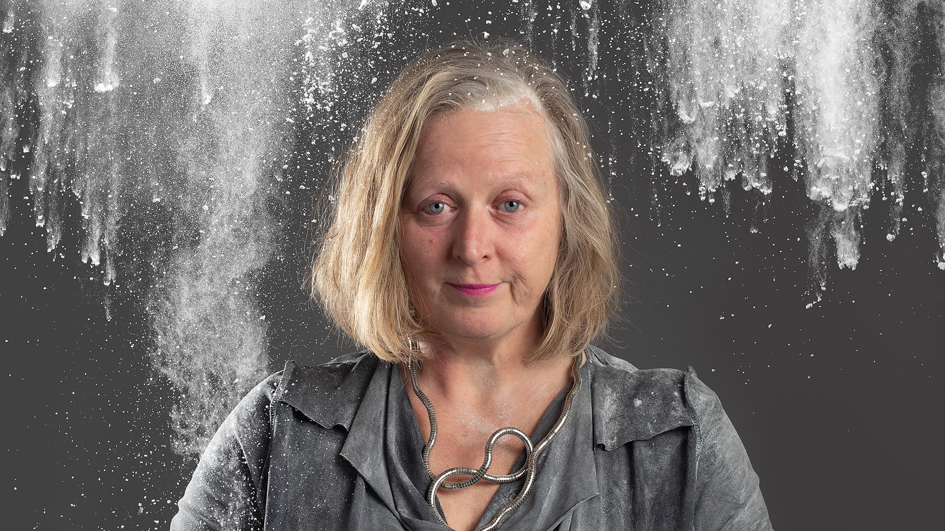 Poster for Self-Raising. Jenny Sealey looks forward whilst flour is thrown all around her.